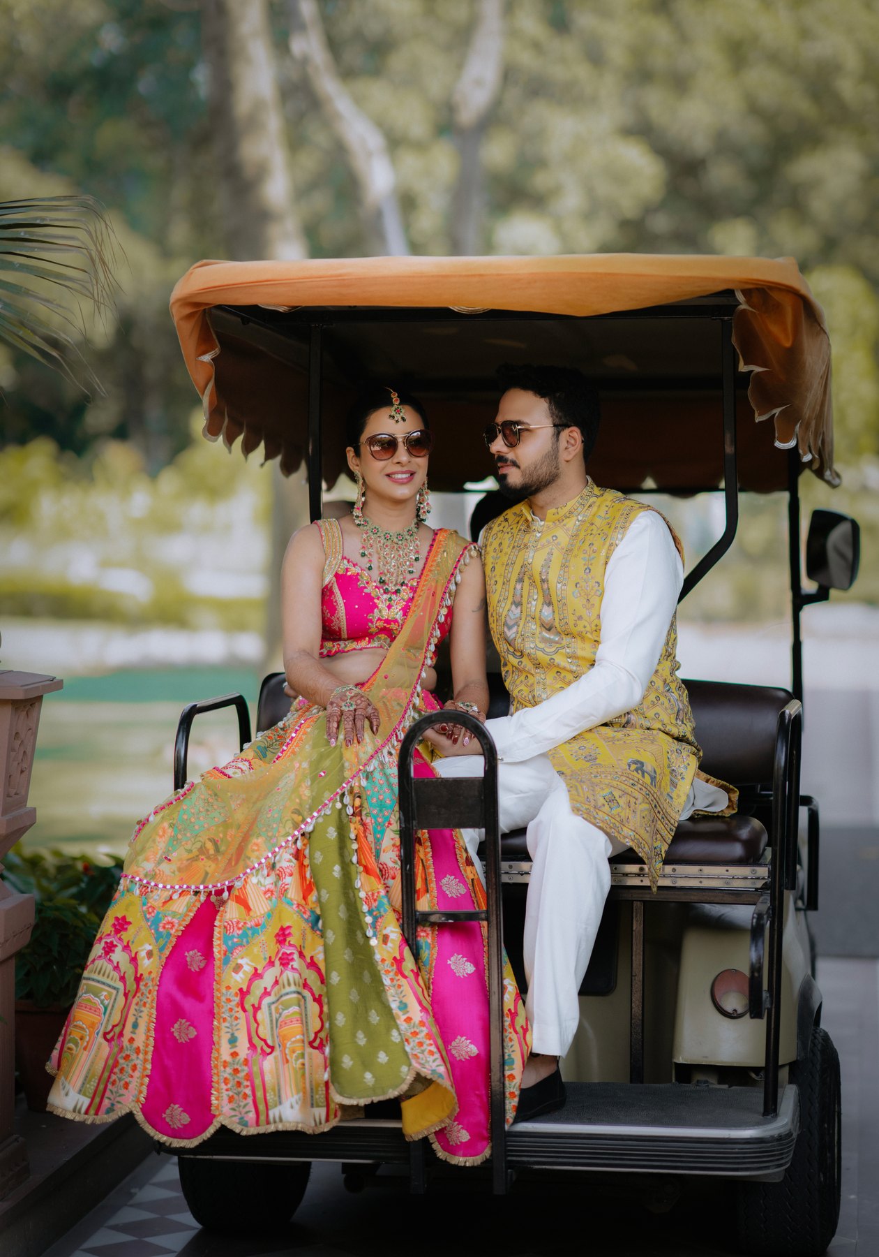 A colourful couple portrait seated together on a garden cart