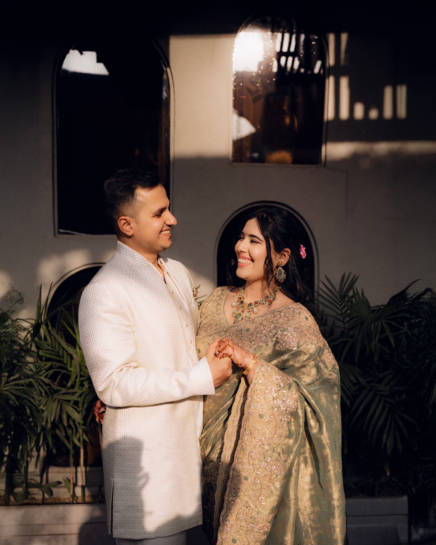 A couple in ivory and gold looking at each other in soft evening light