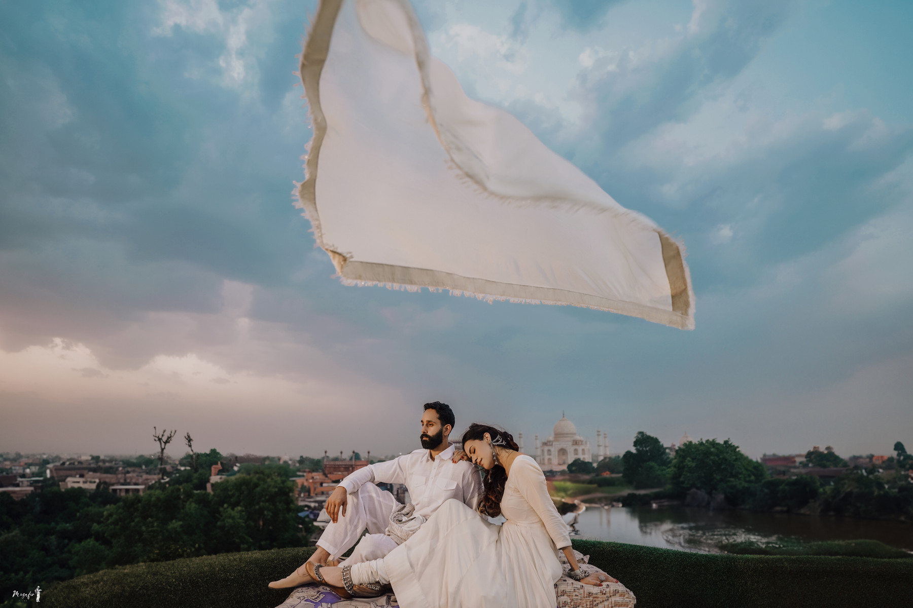 A couple beneath a flowing scarf with the Taj Mahal beyond