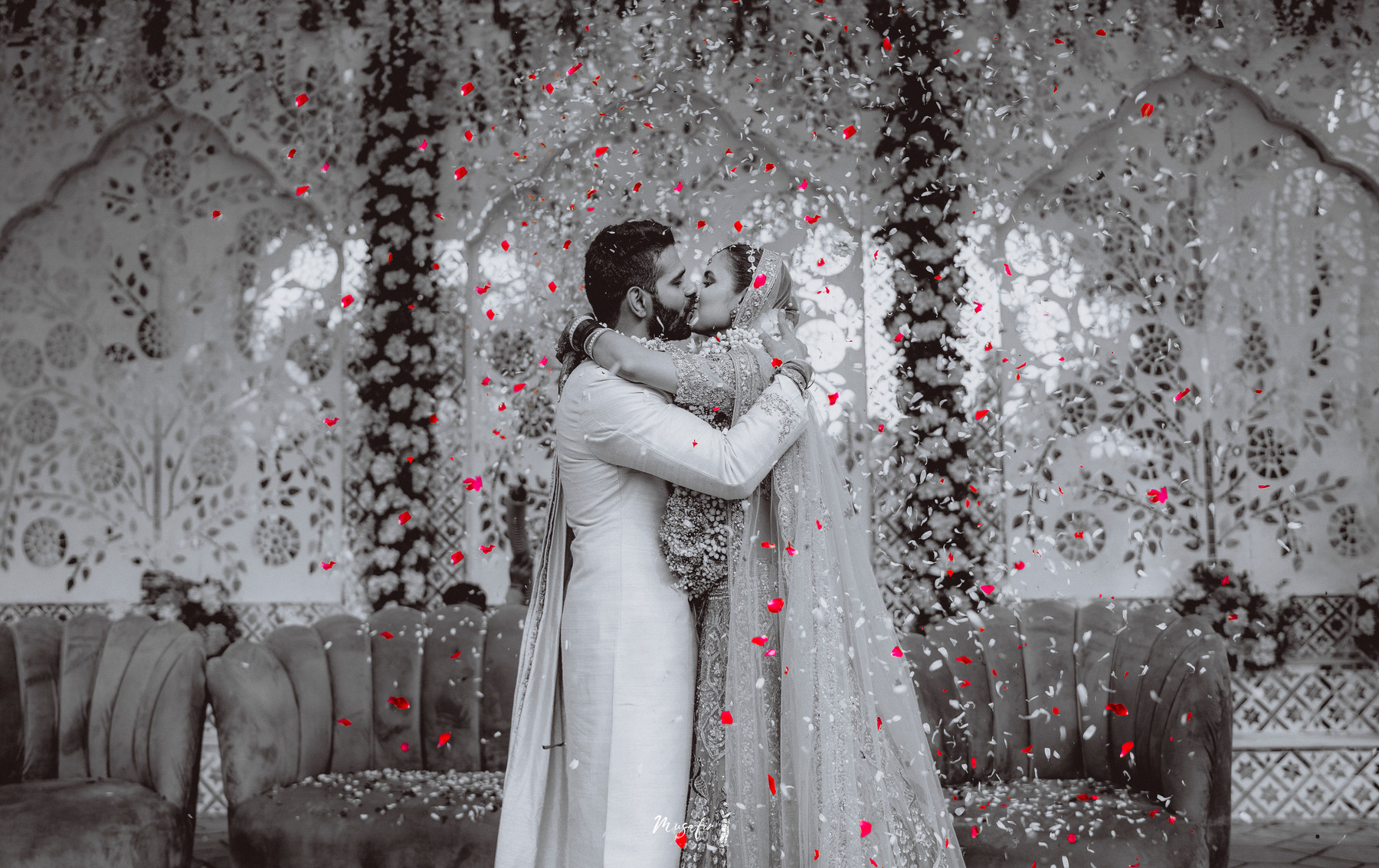 A couple beneath falling petals